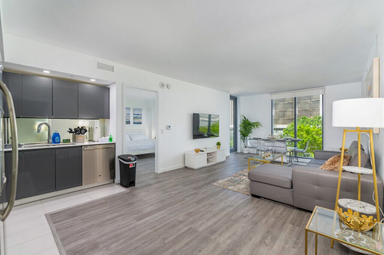 A modern apartment with a kitchen, dining area, and living room.