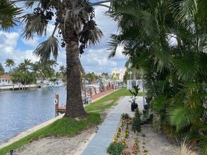 A waterfront hotel with a palm tree-lined walkway, a marina with boats, and a view of the city skyline. - Gorgeous Florida Waterfront Condo 1st Floor, with Large Heated Pool & Patio (Pompano Beach)