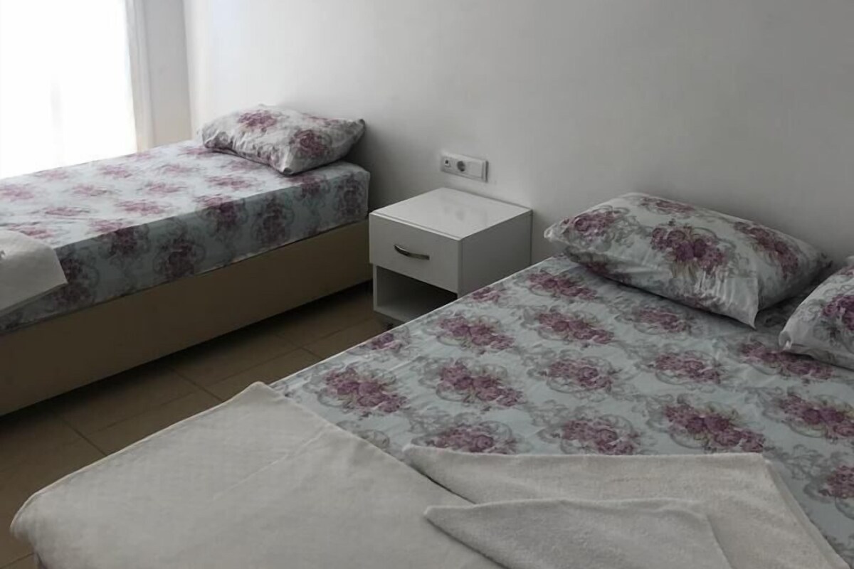 Ein Schlafzimmer mit zwei Betten, einem Nachttisch und einer Wand-Klimaanlage.