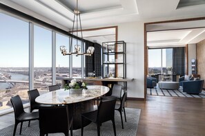 Een moderne eetruimte met een marmeren tafel, zwarte stoelen en een kroonluchter.
