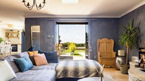 Un salón amplio con una cama grande, una mesa de comedor y vistas al exterior.
