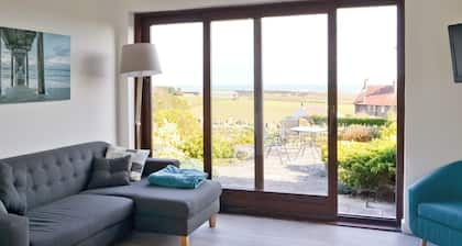 Part of a small terrace of bungalows with uninterrupted views towards the sea.