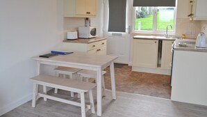 A compact kitchen with white cabinets, a microwave, a toaster, and a sink.