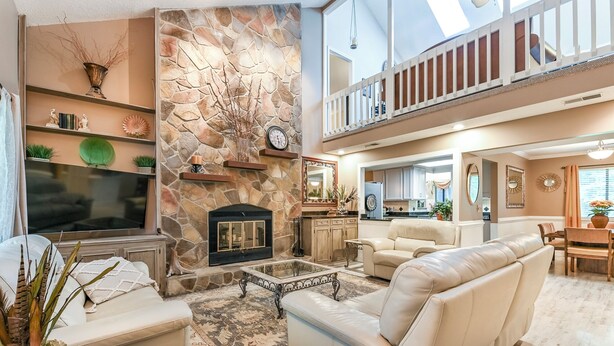 A spacious living area with a stone fireplace, a flat-screen TV, and a comfortable seating arrangement. - Exquisite Summerville Retreat-Walk to Downtown, Festivals & Southern Hospitality (Summerville)