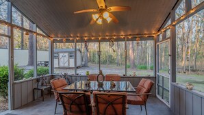 A covered patio with a dining table, chairs, and a ceiling fan. - Exquisite Summerville Retreat-Walk to Downtown, Festivals & Southern Hospitality (Summerville)