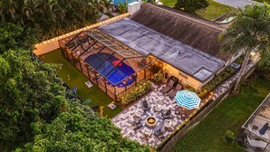 An aerial view of a rooftop pool area with a glass enclosure, outdoor seating, and a fire pit. - Paradise Oasis Heated Pool+Hot Tub+Games & Arcade (Largo)