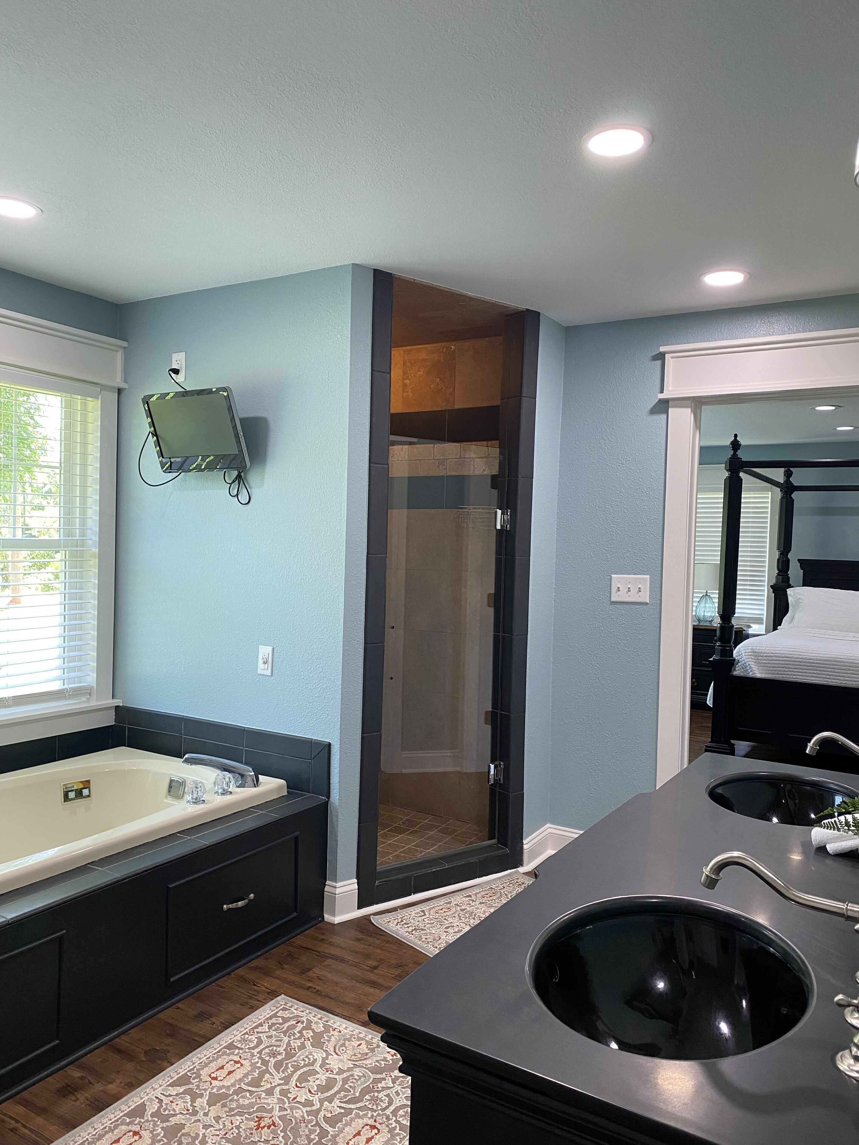 A modern bathroom with a large bathtub, a walk-in shower, and a double sink.
