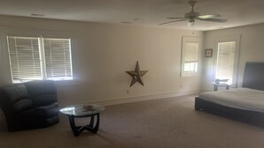 Ein Schlafzimmer mit Bett, einem Sessel, einem kleinen Tisch und einer Stern-Dekoration an der Wand.