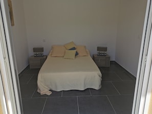 A bedroom with a bed, two bedside tables, and a nightstand.