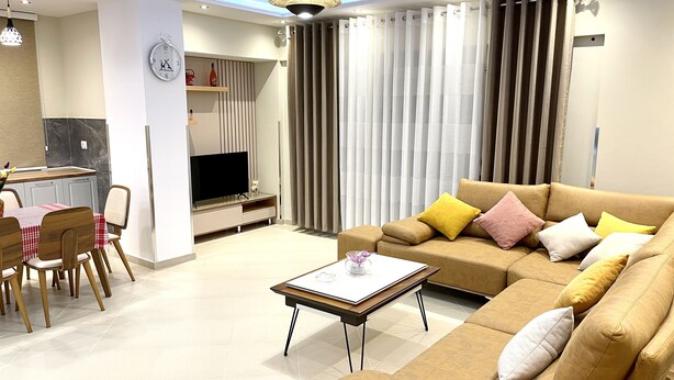 Un salon moderne comprenant un canapé, une table basse et un coin repas avec des chaises et une table.
