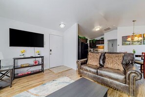 Relax in this stylish living room with a flat-screen TV, comfortable sofa, and wooden coffee table.