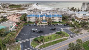 Un hôtel situé en bord de mer, avec plusieurs étages, un parking et une vue sur l’océan.