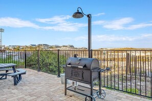 An outdoor patio with a barbecue grill, a table, and a lamp. - Direct Beach Access - Top Floor Unit - Gulf Views From Complex. (Destin)