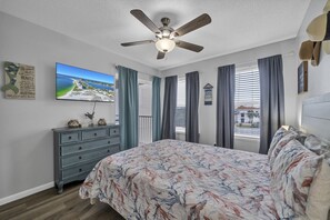 A bedroom with a bed, a ceiling fan, a dresser, a television, and a window with curtains. - Direct Beach Access - Top Floor Unit - Gulf Views From Complex. (Destin)