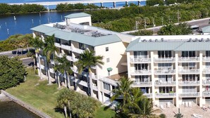 A multi-story hotel with balconies, a pool area, and a waterfront view. - Spectacular Sunset Views! Watch Dolphin from Your Balcony ! (St. Petersburg)