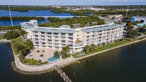 A multi-story hotel with a pool, located near a body of water. - Spectacular Sunset Views! Watch Dolphin from Your Balcony ! (St. Petersburg)