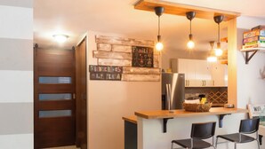 Una cocina moderna con una isla de madera, taburetes de bar y un letrero que dice "WELCOME TO THE BEACH".