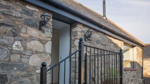 A stone building with a metal staircase and a door.