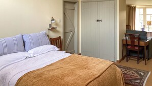 A bedroom with a bed, a desk, a chair, and a door. - Stepping Gate Cottage (Scalby, near Scarborough)