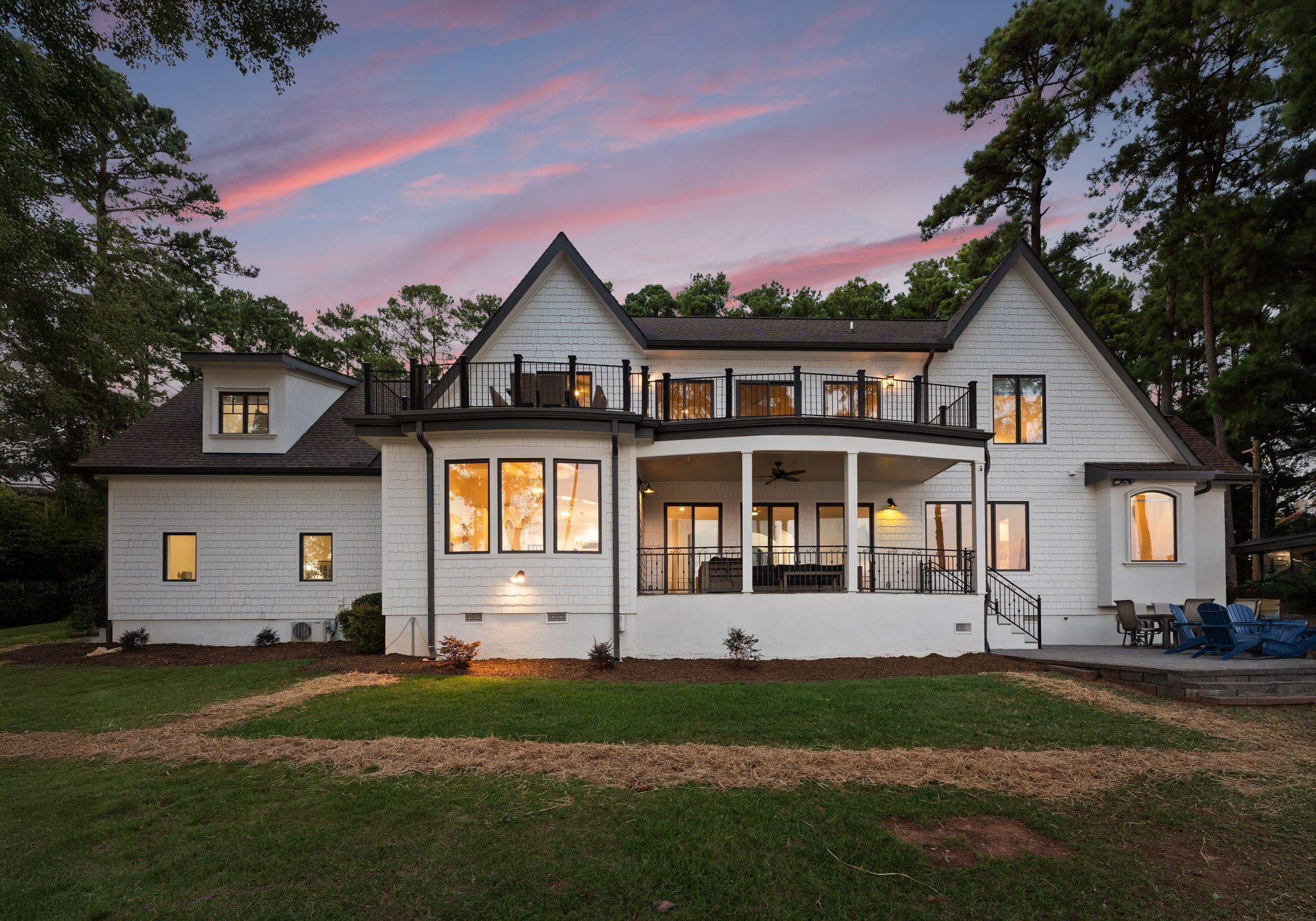 A two-story house with a wrap-around porch, large windows, and a balcony.