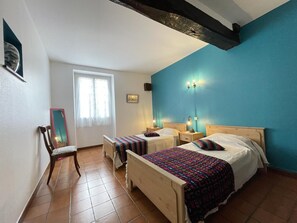 A bedroom with two beds, a chair, a window with curtains, and a blue accent wall. - Barrukia - Uhart-cize (UHART-CIZE)