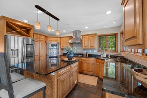 A modern kitchen with wooden cabinets, stainless steel appliances, and a large island.