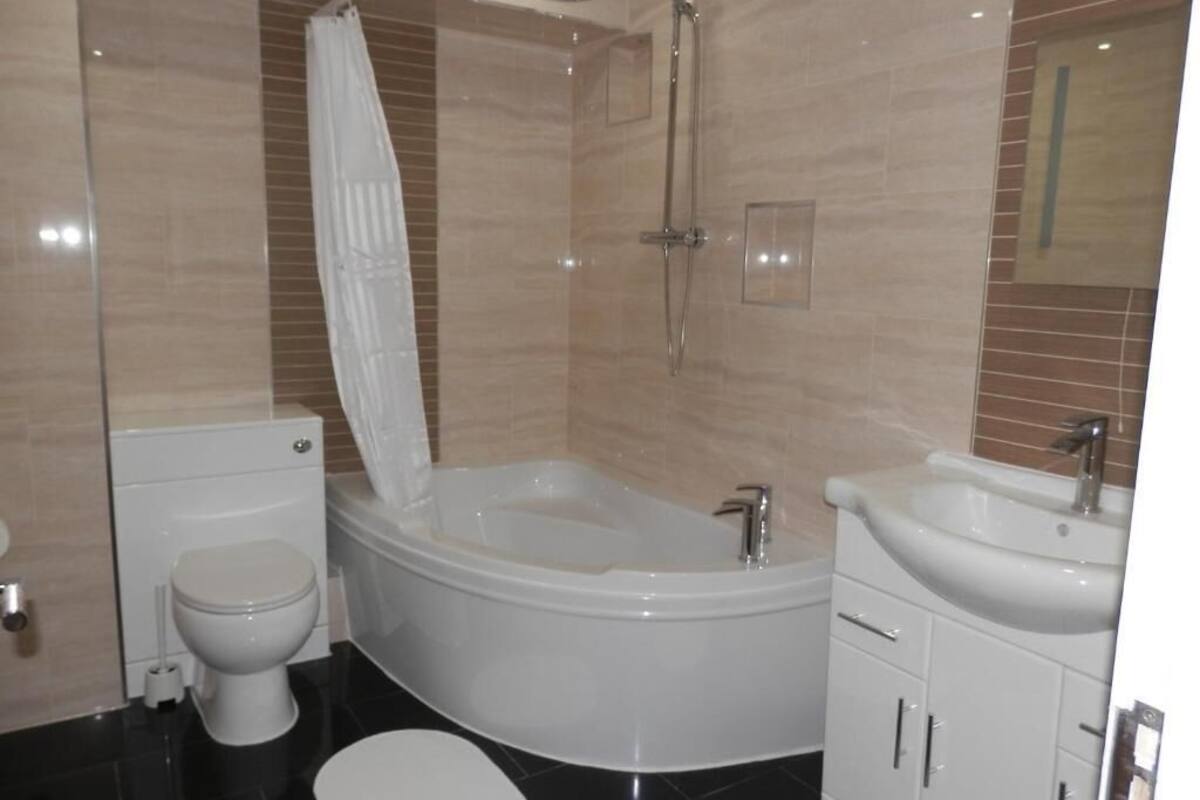 A modern bathroom with a bathtub, toilet, and sink.