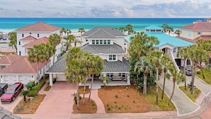 Zona residencial costera con varias casas, un camino de entrada pavimentado y una vista despejada del océano.