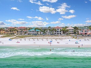 A beachside hotel with multiple buildings, a sandy beach, and ocean view.