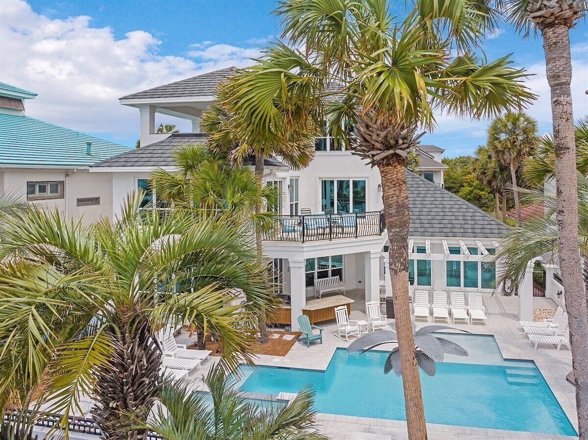 A resort with a pool, lounge chairs, and a two-story building with balconies.