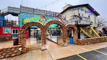 A building with a colorful mural, a staircase, and a unique stone archway.
