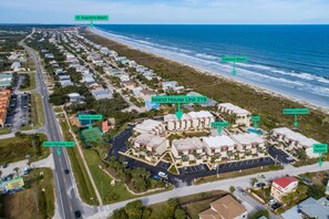 An aerial view of a residential area with a beach, tennis court, clubhouse, and pool. - Island House C219 (St. Augustine)