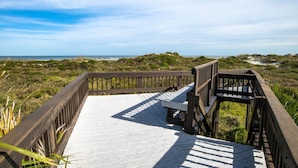 A wooden boardwalk leading to a bench overlooking a beach with dunes and the ocean. - Island House C219 (St. Augustine)