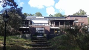A two-story building with a staircase leading to the entrance. - Charmant T2 Carcans Lac Proche Plage Avec Terrasse (CARCANS)