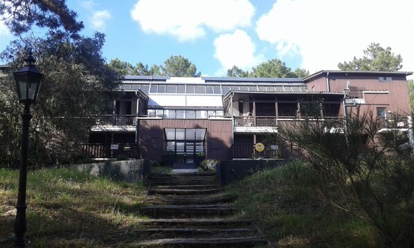 A two-story building with a staircase leading to the entrance.