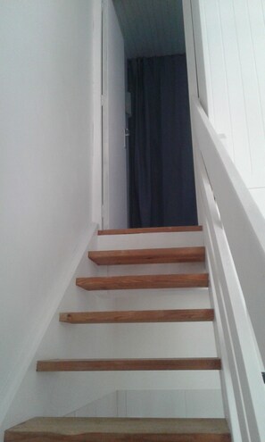 Stairs lead to a spacious interior with a neutral color scheme.
