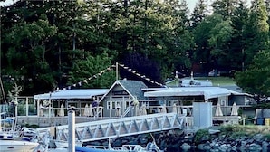 Un port de plaisance avec des bateaux amarrés, un pont couvert et un bâtiment portant l’inscription « Cascades Bay ».