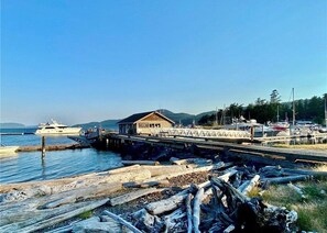 Une propriété située au bord de l’eau, dotée d’un quai, d’un bâtiment à toit en pente et d’un bateau visible au loin.