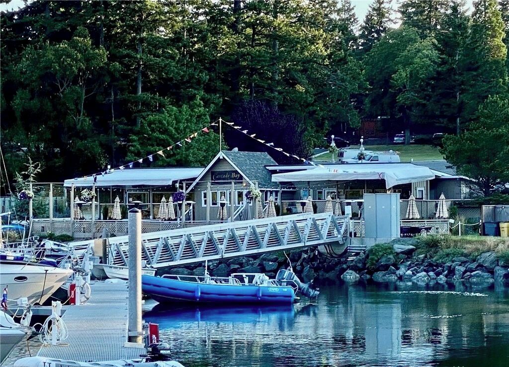 Un port de plaisance avec des bateaux amarrés, un pont couvert et un bâtiment portant l’inscription « Cascades Bay ».