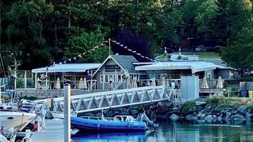 Un port de plaisance avec des bateaux amarrés, un pont couvert et un bâtiment portant l’inscription « Cascades Bay ».