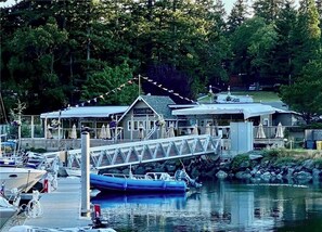 Un puerto deportivo con barcos amarrados, un puente cubierto y un edificio que dice "Cascades Bay".