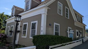 A two-story house with a gabled roof, white trim, and a front porch. - 4 BR Antique Provincetown Single Family Home in the Center of Town - Sleeps 9! (Provincetown)