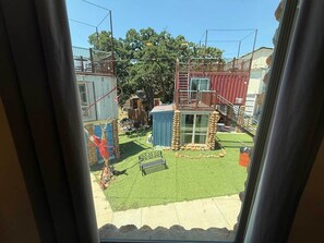 A view of a backyard with a small shed, a bench, and a fenced area.