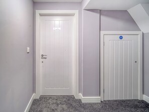 A hallway with two doors, one labeled 'The Boardwalk' and another with a blue sign.