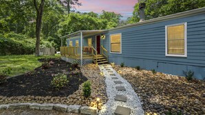 A single-story house with a porch, a stone pathway, and a wooden fence. - Magnolia House w/ 4 Beds 2 Baths on 1.5 Acres ⭐ (Magnolia)