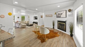 A spacious living room with a modern design, featuring a cowhide rug, white furniture, and a fireplace. - Magnolia House w/ 4 Beds 2 Baths on 1.5 Acres ⭐ (Magnolia)