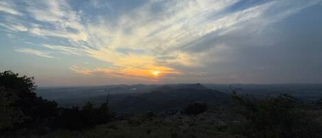 A landscape with a clear sky and a setting sun.