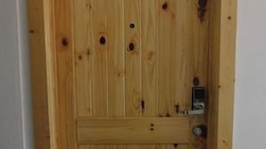 A wooden door with a simple design, a lock, and a handle.