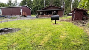 Ett bostadsområde med en välskött gräsmatta, en träterrass och ett hus med en veranda.