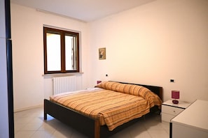A bedroom with a bed, a window, a bedside table, and a desk. - S204 - Sirolo, three-room apartment with large terrace overlooking the sea (La Madonnina)